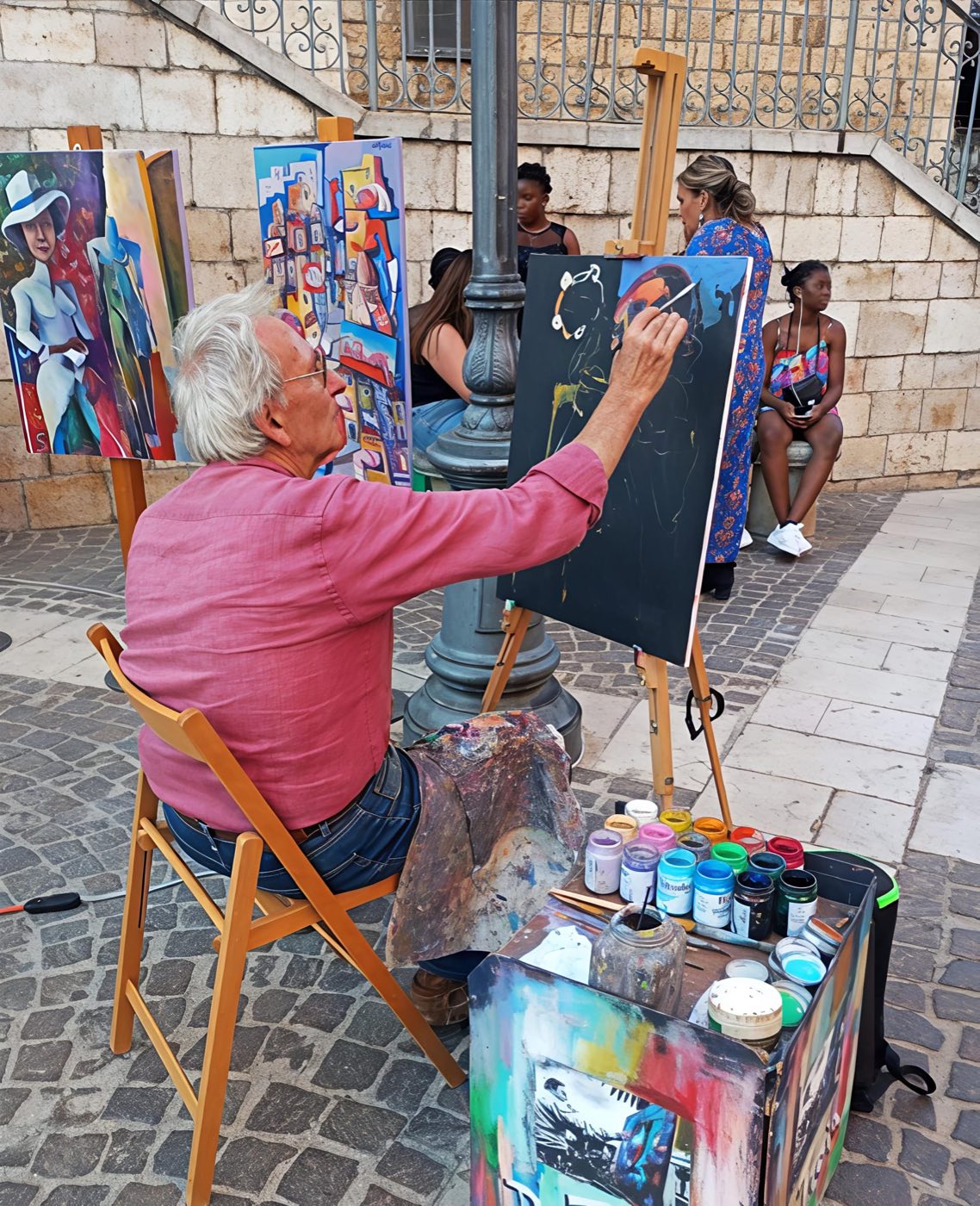 Giacomo De Troia dipinge dal vivo in piazza durante un evento d'arte di strada